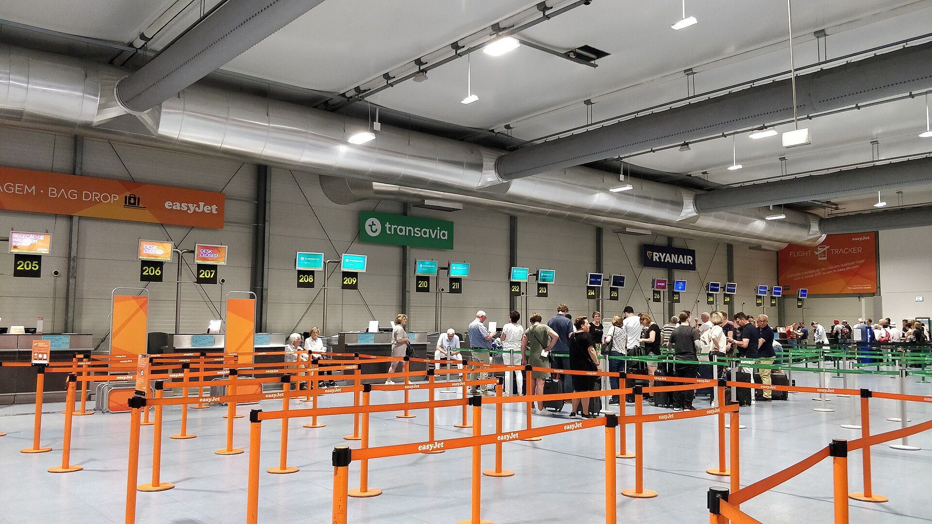 Balcões de check-in no Terminal 2 do Aeroporto de Lisboa, com passageiros em fila