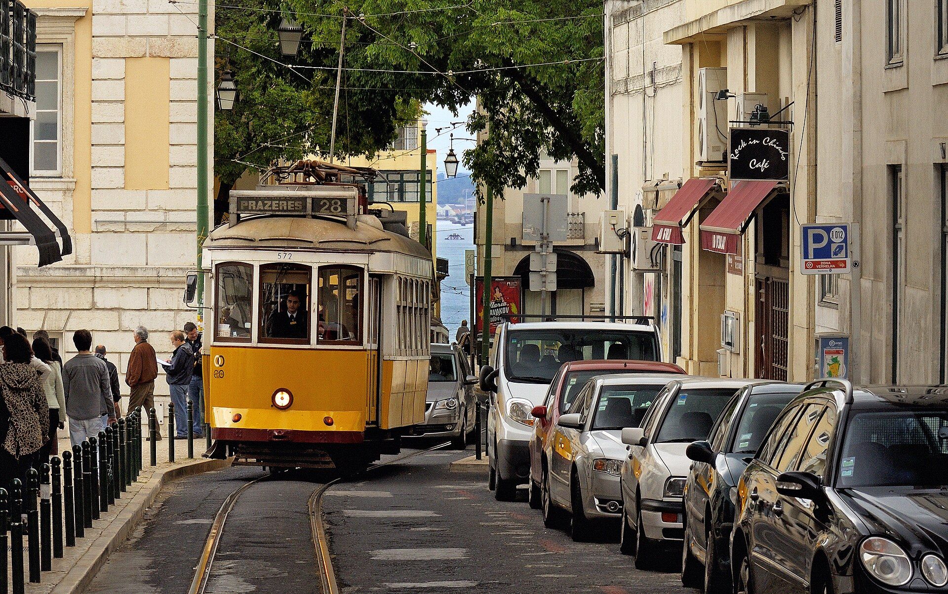 Elétrico amarelo numa rua de Lisboa, com carros estacionados ao lado