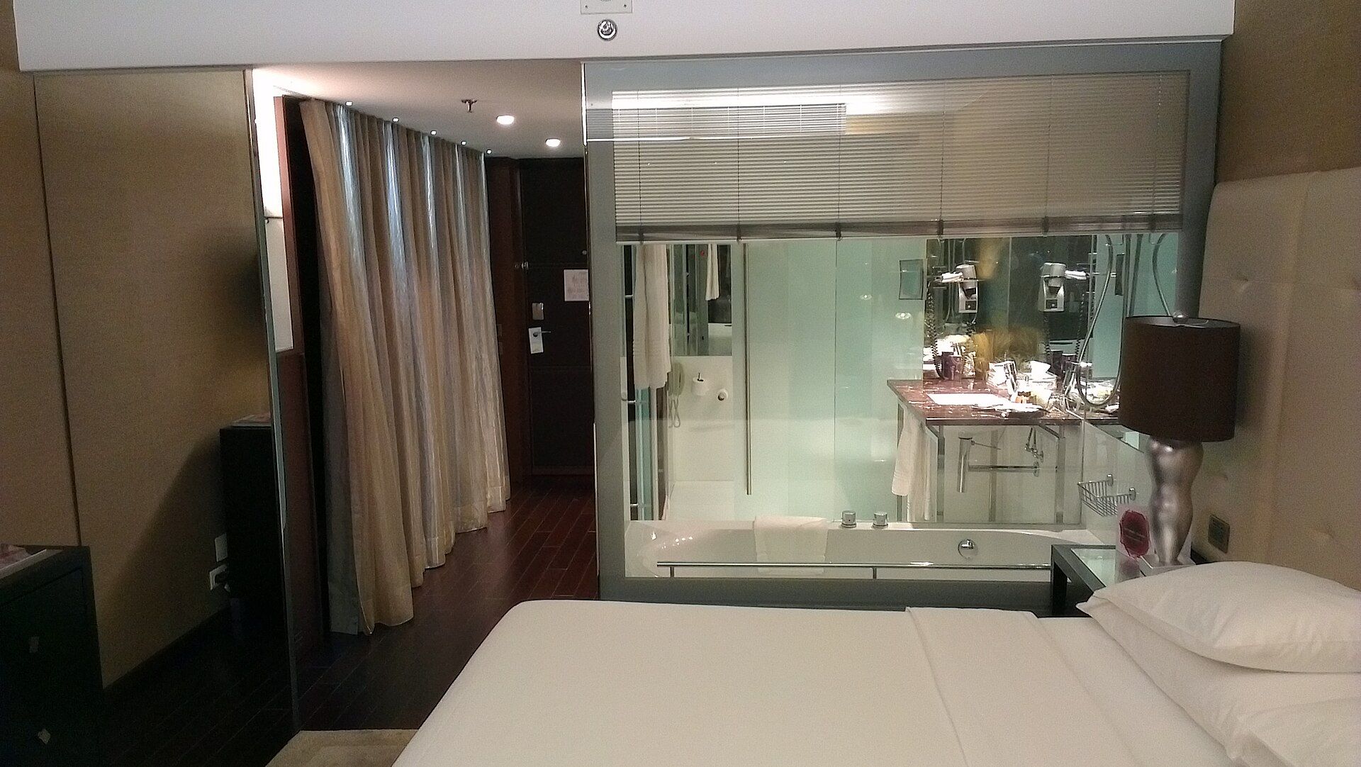 Quarto de hotel em Lisboa, com cama de casal e casa de banho envidraçada ao fundo